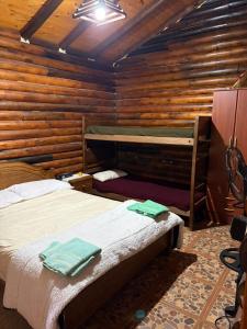 una camera con 2 letti in una baita di tronchi di casa quinta los teritos ad Abasto