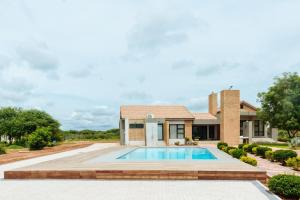 a brick house with a swimming pool in front of it at charming retreat in Gaborone