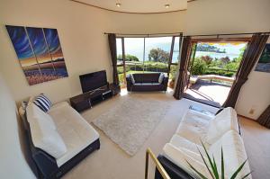 a living room with a couch and a television at The Cliffs - Nelson Waterfront Home in Nelson