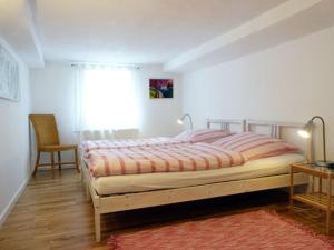 een slaapkamer met een bed, een stoel en een raam bij Gästehaus 1A in Lindlar