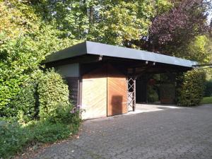 een klein gebouw met een dak op een oprit bij Gästehaus 1A in Lindlar