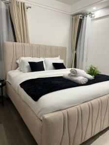 een slaapkamer met een groot bed met witte lakens en kussens bij Polaris residency in Nairobi