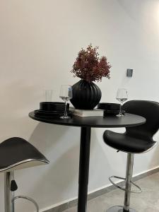 een zwarte tafel met glazen en een vaas erop bij Polaris residency in Nairobi