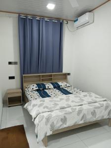 HanimaadhooBlue Rose Room Service的卧室里有一张带蓝色窗帘的床