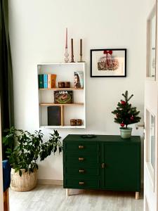a green dresser in a living room with a christmas tree at Art gallery near Pardubice in Mateřov