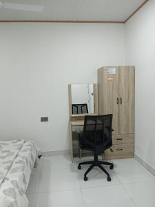 HanimaadhooBlue Rose Room Service的一间卧室配有一张桌子和一张椅子,位于床边