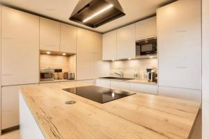 a kitchen with a wooden counter top in a room at Résidence Alpine Loft - 5 Pièces 10 pers- HAUT DE GAMME - ALPINE LOFT - 10ALPI - PLAGNE CENTRE MAE-2634 in Aime-La Plagne