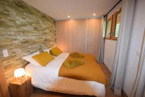 a bedroom with a large bed with yellow pillows at Résidence Alpine Loft - 5 Pièces 10 pers- HAUT DE GAMME - ALPINE LOFT - 10ALPI - PLAGNE CENTRE MAE-2634 in Aime-La Plagne