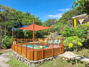 a large pool with a wooden deck with an umbrella at La Casa del Conde in Playa Naranjo