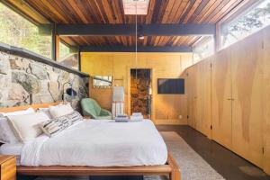 a bedroom with a large bed and a stone wall at Two Creeks Treehouse in Mill Valley