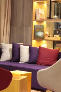 a purple couch with red and white pillows on it at Campanile Shanghai Bund Hotel in Shanghai