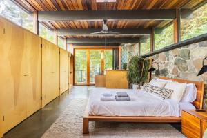 a bedroom with a large bed and a stone wall at Two Creeks Treehouse in Mill Valley
