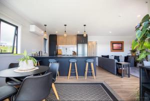 a kitchen and living room with a table and chairs at Raglan Sun Seekers Retreat in Raglan