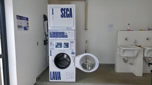 a bathroom with a washing machine and a sink at Apartamento 1 Completo com Piscina e Academia ao lado da USP in São Carlos +35 photos