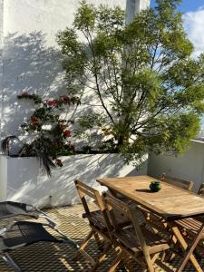 a wooden table and chairs on a patio with flowers at Dar el Marsa in Tangier
