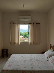a bedroom with a bed and a window at Suítes XIBAYKA in Ilhabela