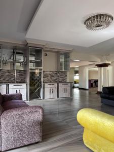 a living room with a couch and a large kitchen at Paradiso Palazzo in Welkom
