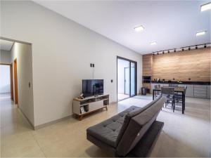 een woonkamer met een bank en een tv bij Casa com Piscina, Wi-Fi e Garagem in Pirassununga