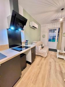 a living room with a desk with a monitor on it at Les Jardins Bas in Moulins