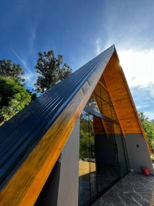 a house with a metal roof on top of it at Chalé Rio Capetinga 02 in Anchieta