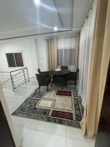 una sala de estar con una mesa y sillas en Happiness House Gambia, en Banjul