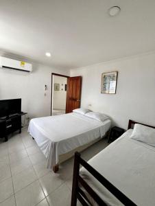 a hotel room with two beds and a piano at Paraíso en Bocagrande Apartaestudio in Estación El Salto