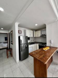 a kitchen with a wooden counter and a refrigerator at Paraíso en Bocagrande Apartaestudio in Estación El Salto