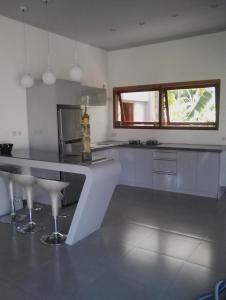 a kitchen with white cabinets and a counter top at Ju'Blu Villa in Lovina