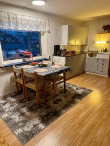 a kitchen with a table and chairs in a room at Fjord Haven in Gryllefjord