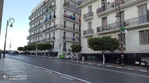 an empty street in front of a large building at Appartement 3 pièces in LʼAgha