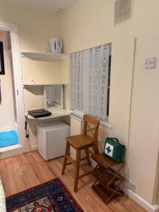 eine kleine Küche mit einem Stuhl und einem Herd in der Unterkunft Heathrow Direct in Hillingdon