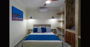 ein Schlafzimmer mit einem Bett mit blauen Kissen in der Unterkunft Santa Cruz Suites in La Paz