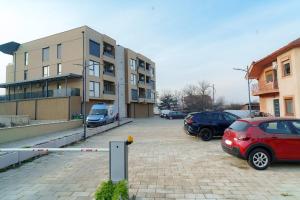 a parking lot with cars parked in front of a building at Modern apartment with terrace in Petrovec in Petrovec