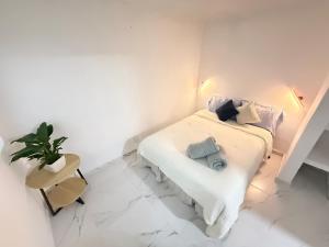 a white bedroom with a bed and a potted plant at Depto planta baja Cuautitlán izcalli in Cuautitlán Izcalli