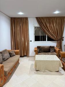 a living room with two couches and a window at Harhoura stay in Temara