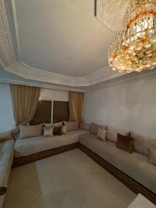a living room with a couch and a chandelier at Harhoura stay in Temara