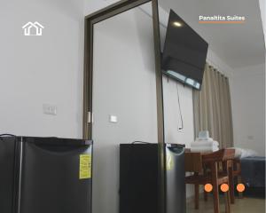 a black refrigerator and a tv in a room at PanaltitaSuites in Cancún