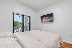 a white bedroom with a bed and a window at Modern Miami Home with Patio and Pool in Country Walk