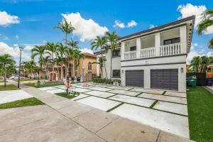 a house with a garage and palm trees at Modern Miami Home with Patio and Pool in Country Walk