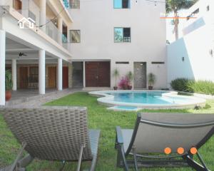 a backyard with two chairs and a swimming pool at PanaltitaSuites in Cancún