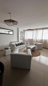 un soggiorno con divani bianchi e un tappeto di Depto Ro a Villa Carlos Paz