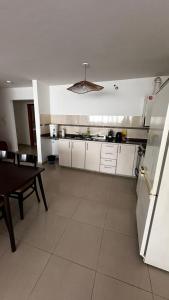 una cucina con armadi bianchi e un tavolo di Depto Ro a Villa Carlos Paz