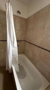bagno con vasca e tenda doccia di Depto Ro a Villa Carlos Paz