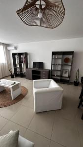 un soggiorno con divano bianco e ventilatore a soffitto di Depto Ro a Villa Carlos Paz