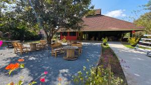 eine Terrasse mit Tischen und Stühlen vor einem Gebäude in der Unterkunft OneSeasonFarm in Chiang Saen