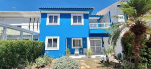ein blau-weißes Haus mit einer Palme in der Unterkunft Fantástica Casa 03 Quartos nas belíssimas Praias do Flamengo in Salvador