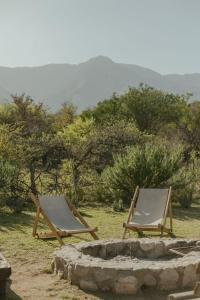 圣哈维尔Glamping Traslasierra Carpa Sur的两张躺椅摆放在火坑旁边。 更多15张照片