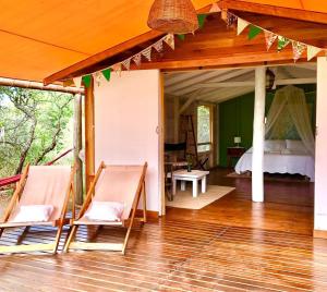 a room with a bed and chairs on a wooden floor at Glamping Traslasierra Carpa Sur in San Javier
