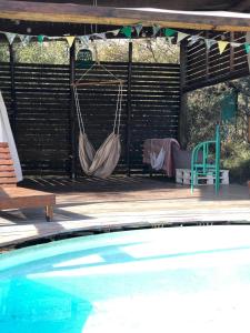 圣哈维尔Glamping Traslasierra Carpa Sur的两张吊床悬挂在泳池旁的凉亭上