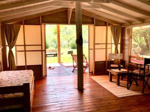 a living room with a wooden floor and glass doors at Glamping Traslasierra Carpa Sur in San Javier